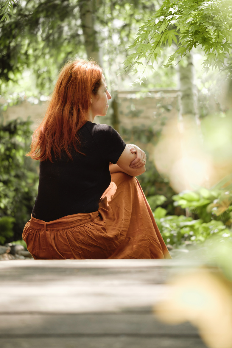 Woman in Her 40S Sitting on Road Looking Away in Garden