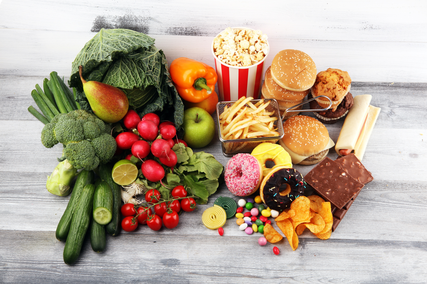 healthy or unhealthy food. Concept photo of healthy and unhealthy food. Fruits and vegetables vs donuts and fast food